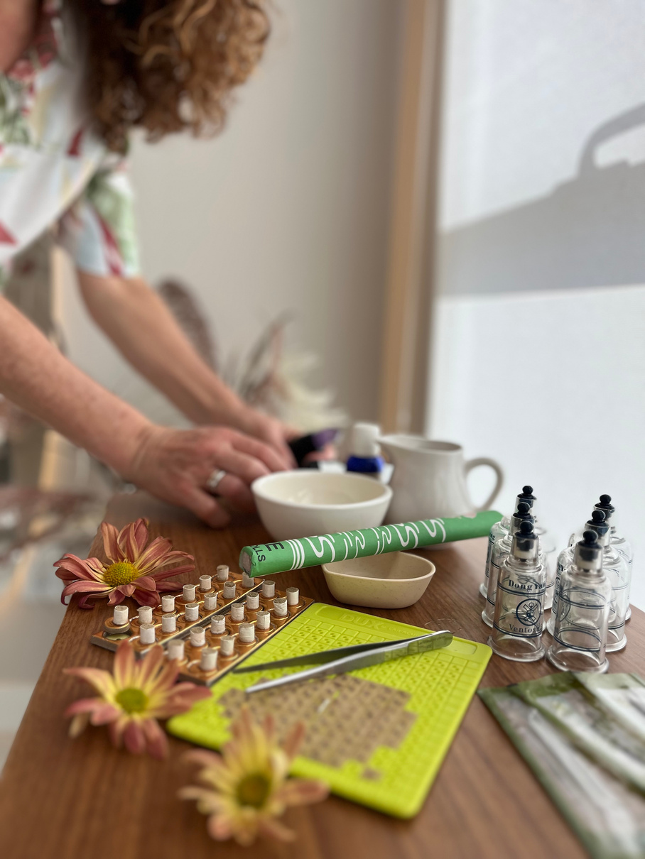 Marly preparando materiais de terapia: ventosas, sementes de auriculoterapia e moxa